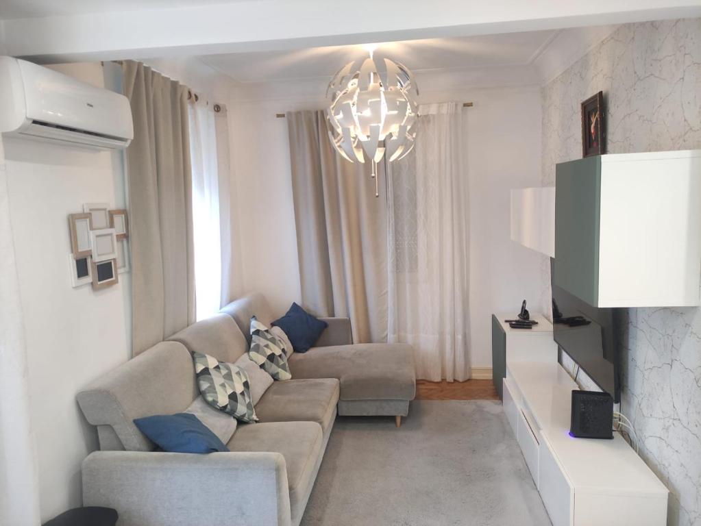 a living room with a couch and a chandelier at Memo Moscavide Guest House in Lisbon