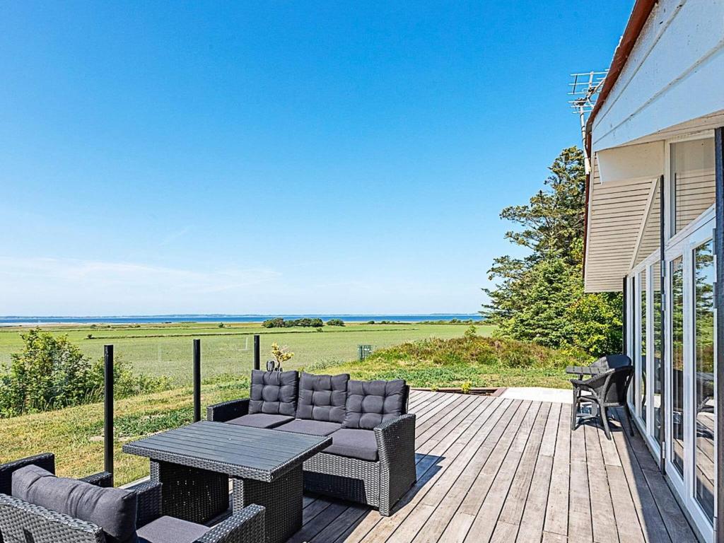 a patio with a couch and a table on a deck at 7 person holiday home in Højslev-By Traum in Højslev