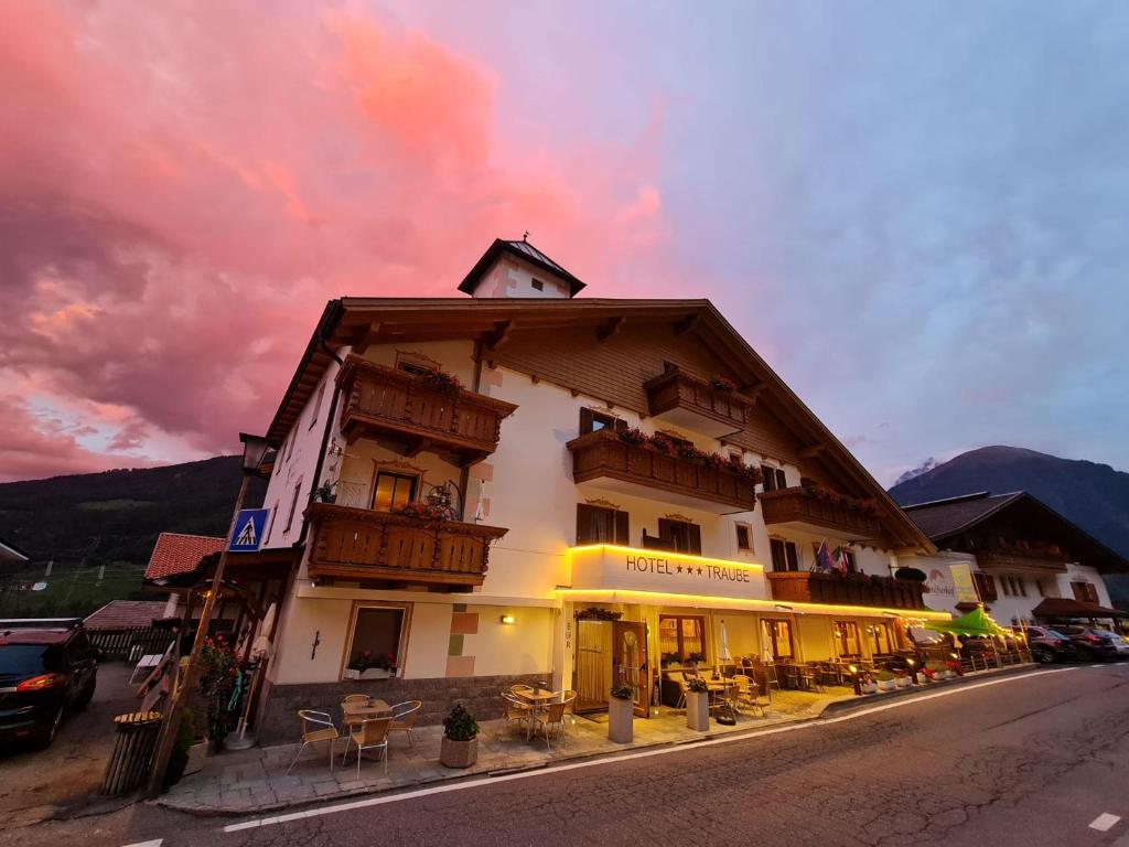 a large building with tables and chairs on a street at Hotel Traube - Stelvio in Stelvio