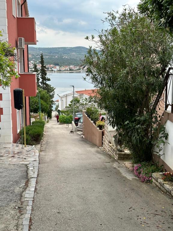 an empty street between two buildings with a body of water at Beachouse Villa Tatijana in Rogoznica