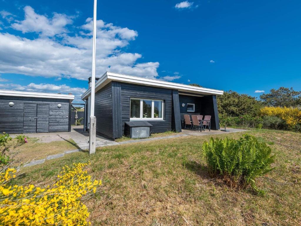 una casa modular negra con patio en Holiday home Fanø CCVII en Fanø