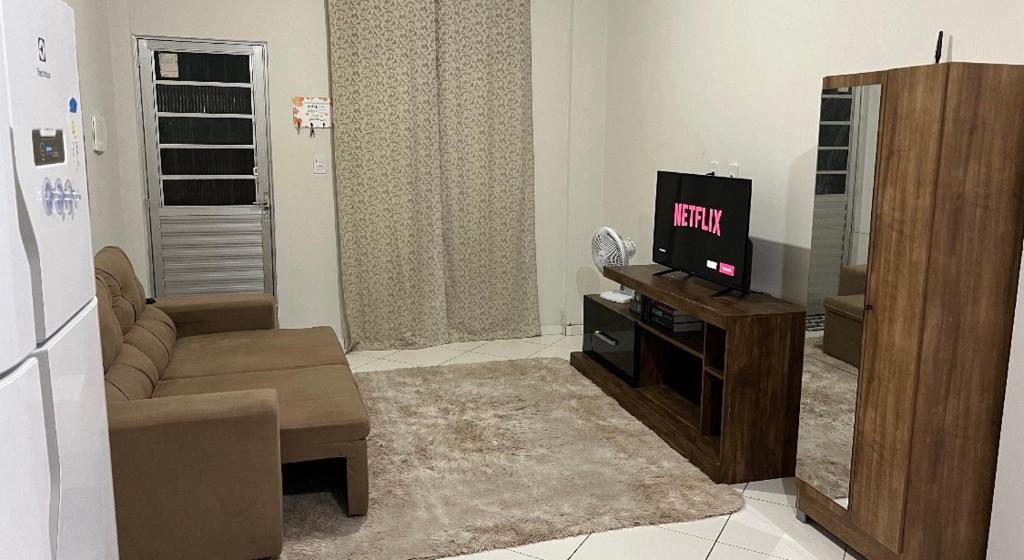 - un salon avec une télévision et un canapé dans l'établissement Apartamento em plena Doca, à Belém