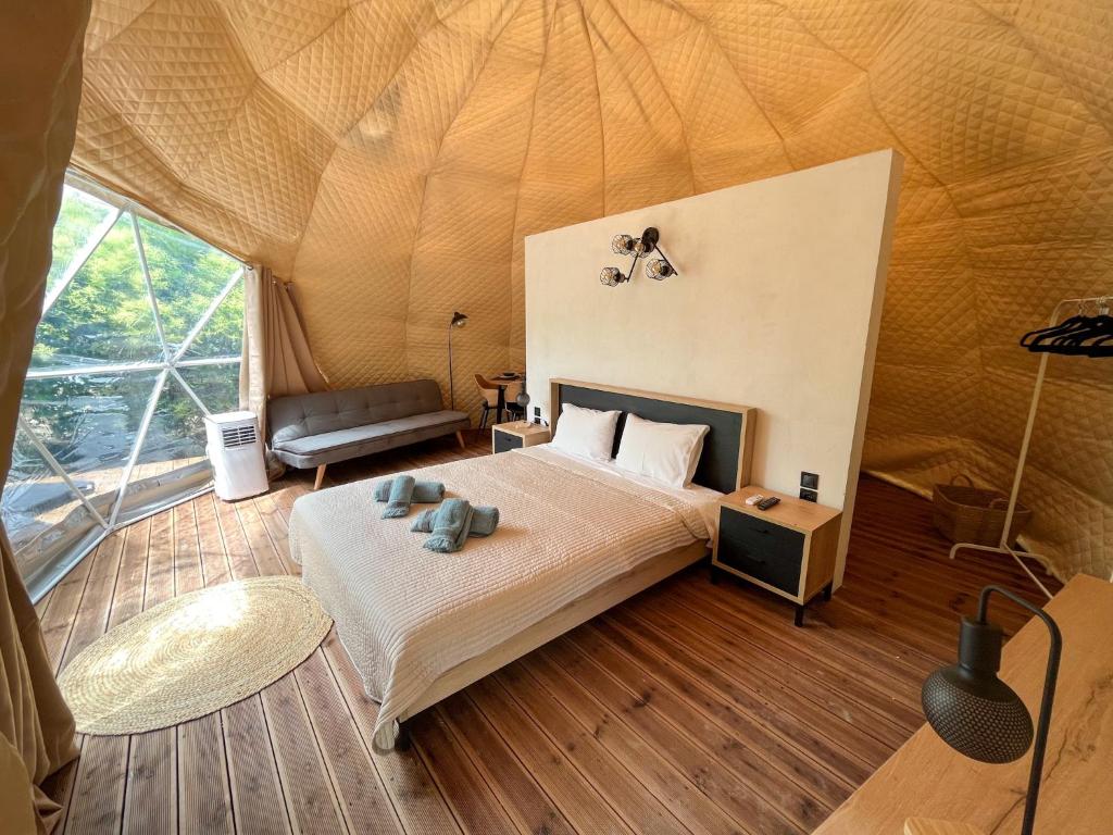 Manna Gea Glamping Domes في فونيتسا: غرفة نوم بسرير في خيمة