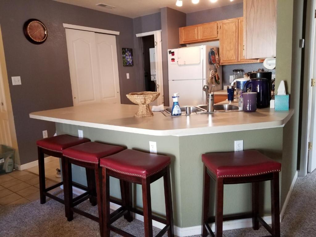 a kitchen with a large island with red bar stools at Lovely Mountain condo, remote workspace, 2 kayaks next to Lake Dillon in Frisco