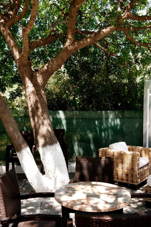 a table and chairs next to a tree at Aphrodite Samos Suites in Marathokampos