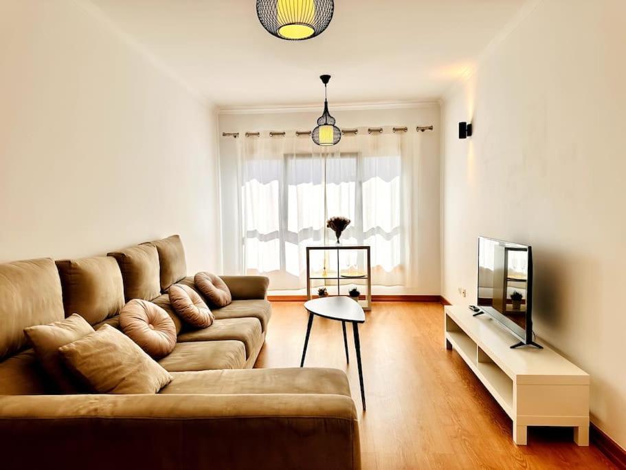 a living room with a couch and a television at Sweety Bela Vista Apartment in Lisbon