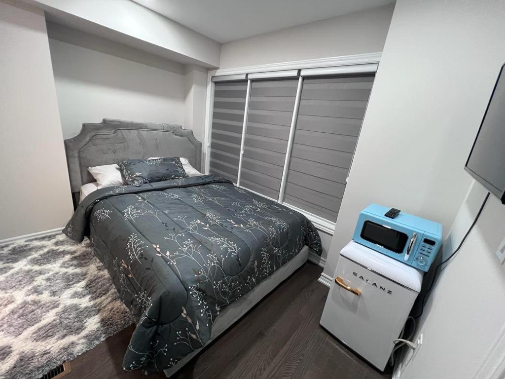Un dormitorio con una cama y un televisor. en New Kleinburg Towns, en Woodbridge