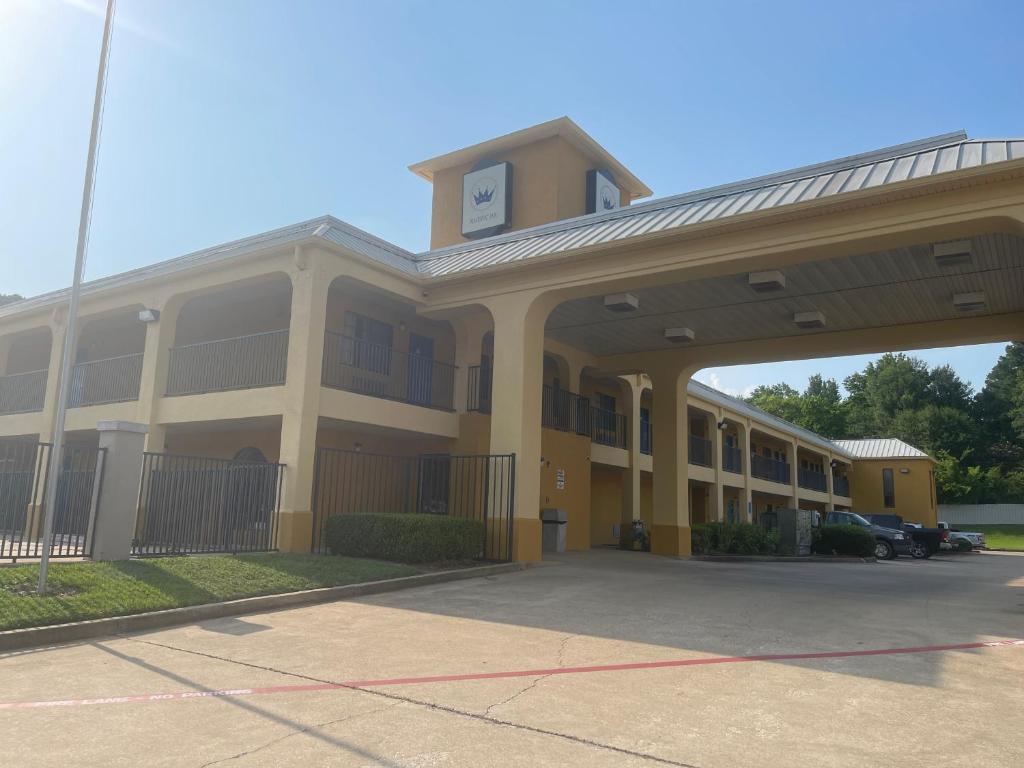 a large yellow building with a parking lot at Majestic Inn in Longview