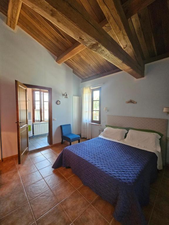 a bedroom with a blue bed and wooden ceilings at La Casa dei Tigli in Cannara