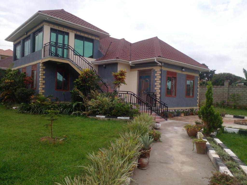 a house with a pathway in front of it at Alice Gardens and Campsite in Entebbe