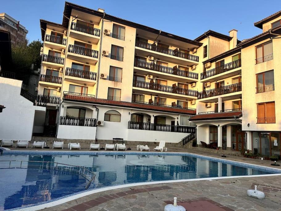 a hotel with a swimming pool in front of a building at Spacious Fully Furnished Studio in Kavarna Apart Hotel in Kavarna