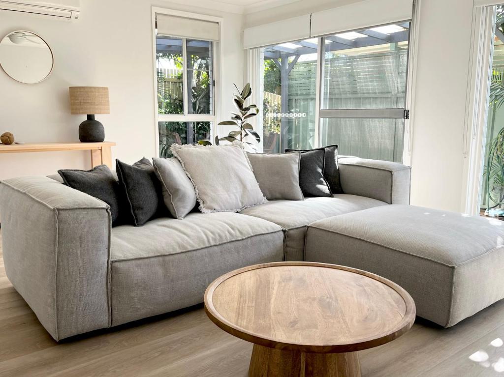 Una sala de estar con un sofá y una mesa de café. en Som House 1, en Shoal Bay