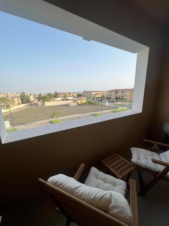 a room with two chairs and a large window at شقة الاحلام in King Abdullah Economic City