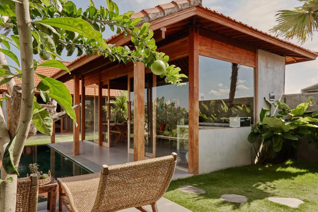 ein Haus mit einem Wintergarten mit einem Tisch und Stühlen in der Unterkunft Bruann Villa 3 Pererenan, Seseh, Canggu, amazing view, 2 bedroom in Mengwi