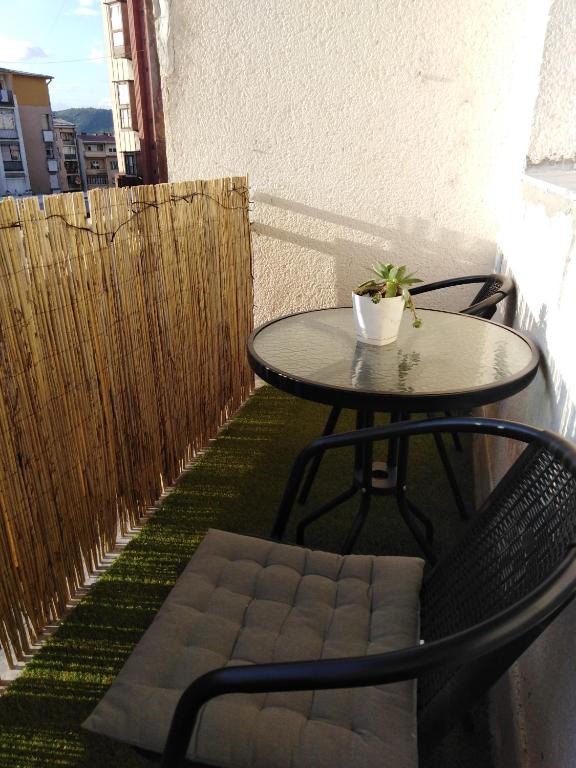 a table and chairs on a balcony with a small table and a table at Apartman REA 1 in Pirot