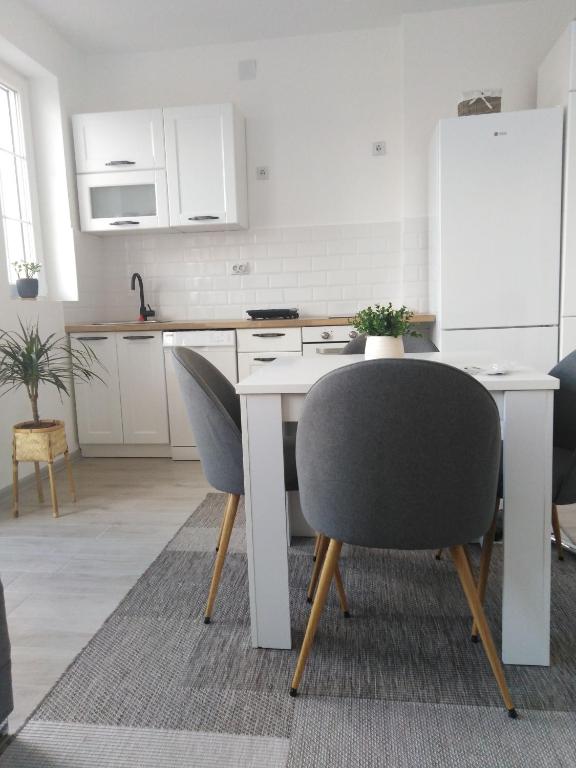 a kitchen with a table and two chairs and a refrigerator at Apartman REA 1 in Pirot