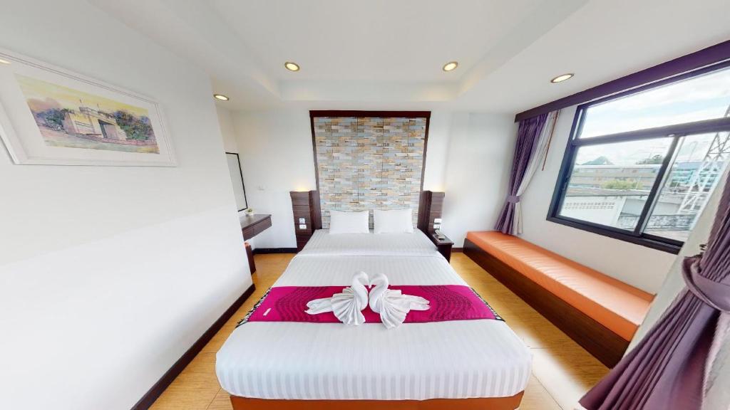 1 dormitorio con 2 camas y ventana en Serene Residence, en Kanchanaburi