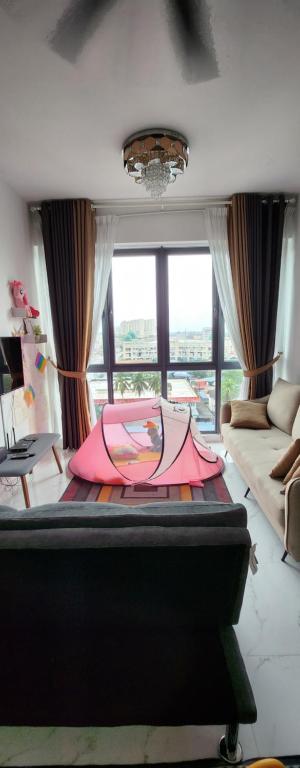 a pink umbrella laying on a bed in a room at Prestige Troika Kota Bharu in Kota Bharu