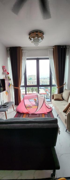einen rosa Regenschirm auf einem Bett in einem Zimmer in der Unterkunft Prestige Troika Kota Bharu in Kota Bharu