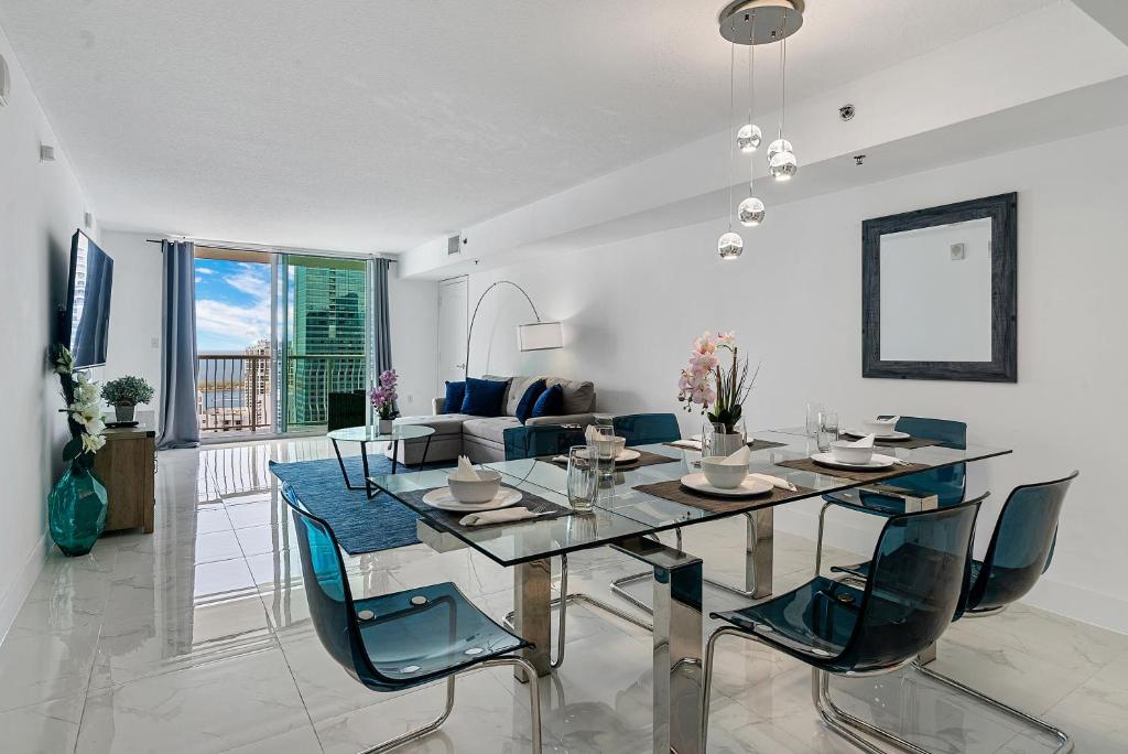 a dining room with a glass table and chairs at Awesome Penthouse Apt Brickell W/Pool in Miami