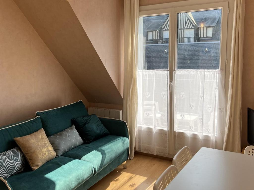 uma sala de estar com um sofá verde e uma janela em Appartement Cabourg, 3 pièces, 4 personnes - FR-1-794-83 em Cabourg