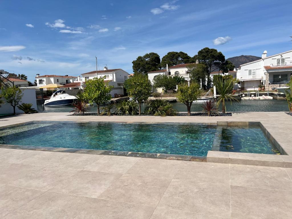 uma piscina no meio de um pátio com casas em Villa de luxe avec amarre Rosas em Roses