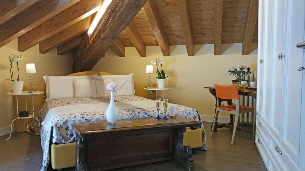 een slaapkamer met een bed en een tafel met een vaas erop bij Villa Monti in Varenna