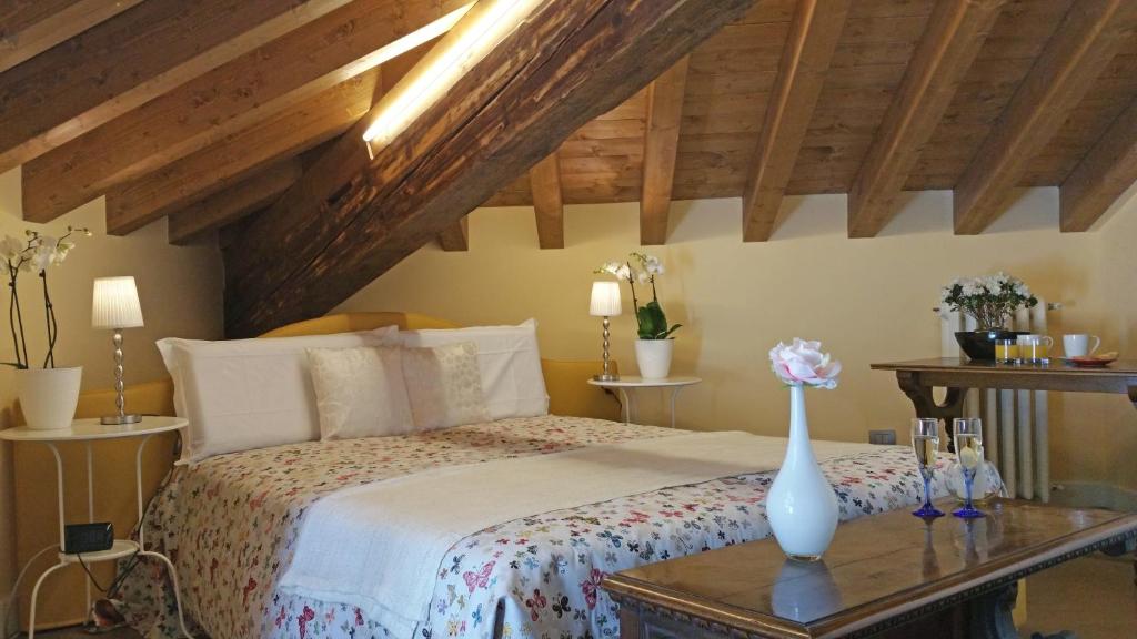 een slaapkamer met een bed met een vaas op een tafel bij Villa Monti in Varenna