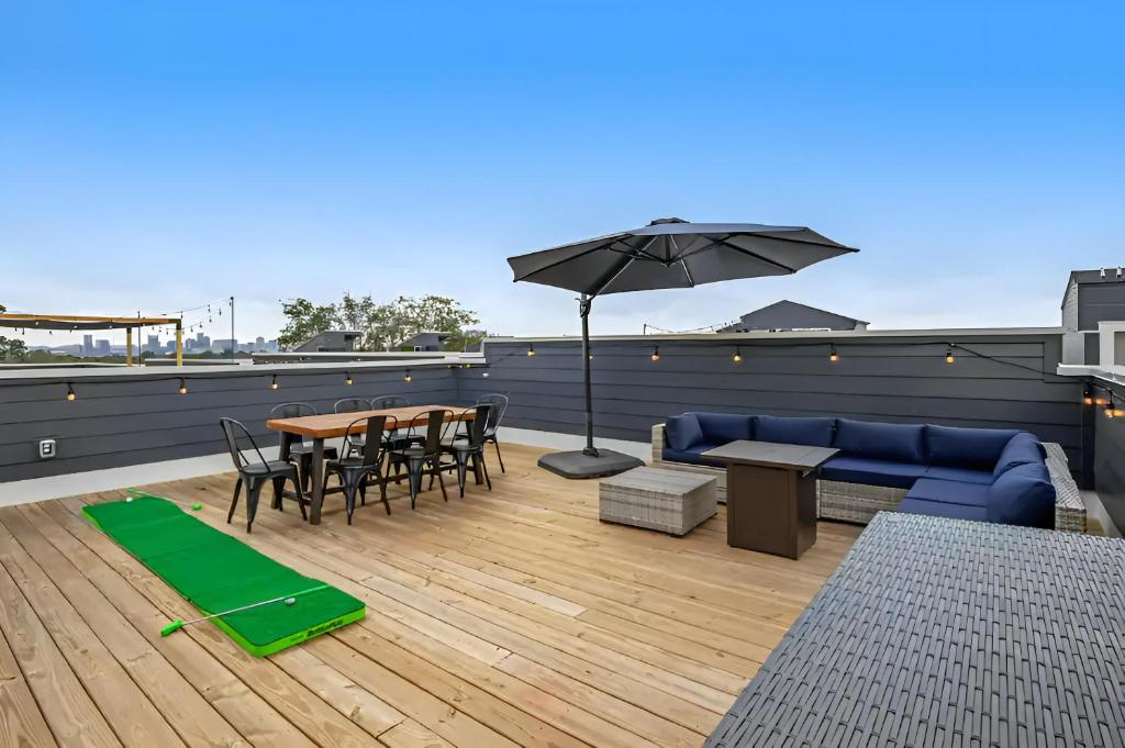 a patio with a blue couch and a table and an umbrella at Rooftop Skyline View - Karaoke Stage - 4 Bedroom in Nashville