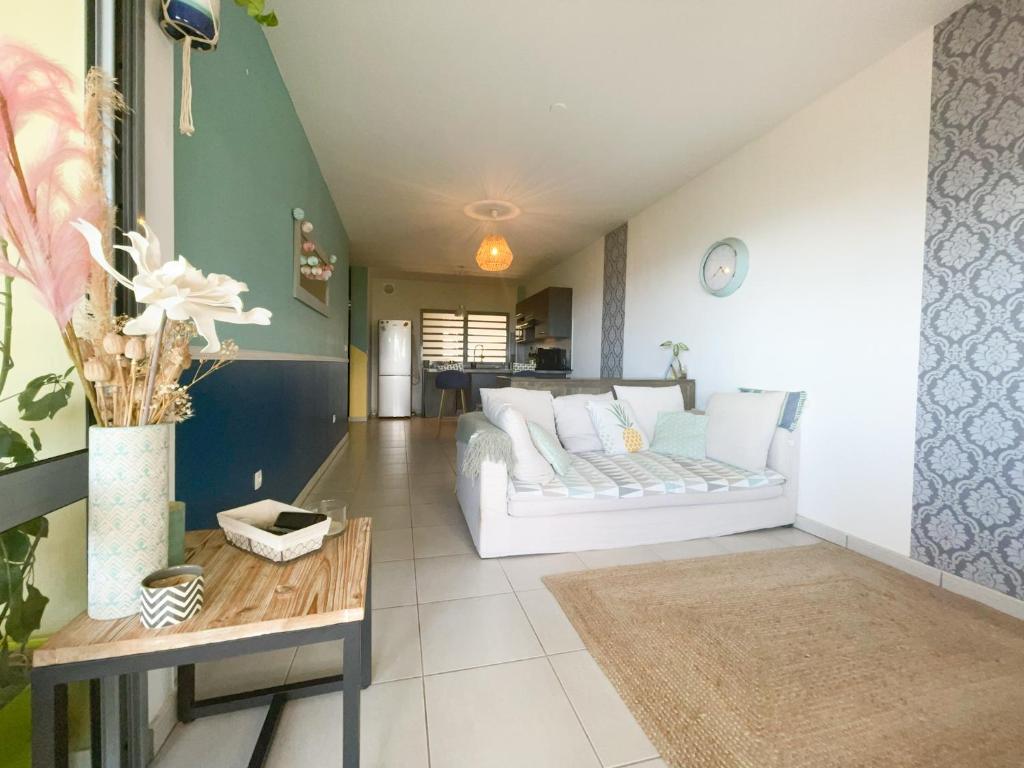 - un salon avec un canapé blanc et une table dans l'établissement Le Cocon Appartement Vue Mer et Montagne, à Sainte-Marie