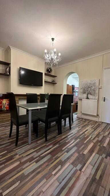 a dining room with a table and chairs and a television at Palaz 7 - 5 bedroom house in Edmonton