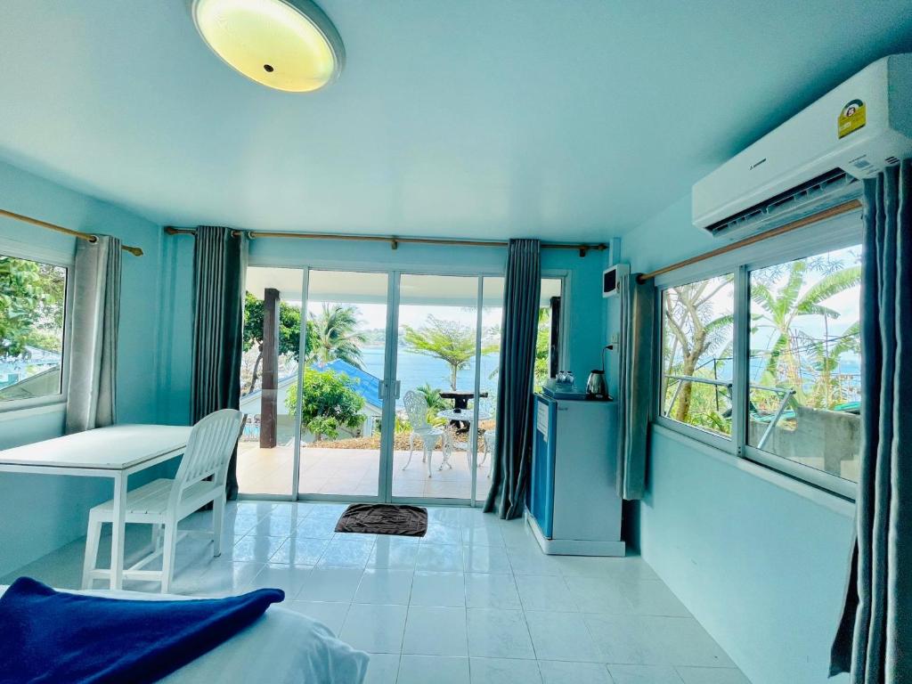 a bedroom with a bed and a view of the ocean at Naiharn On The Rock Resort Phuket in Nai Harn Beach