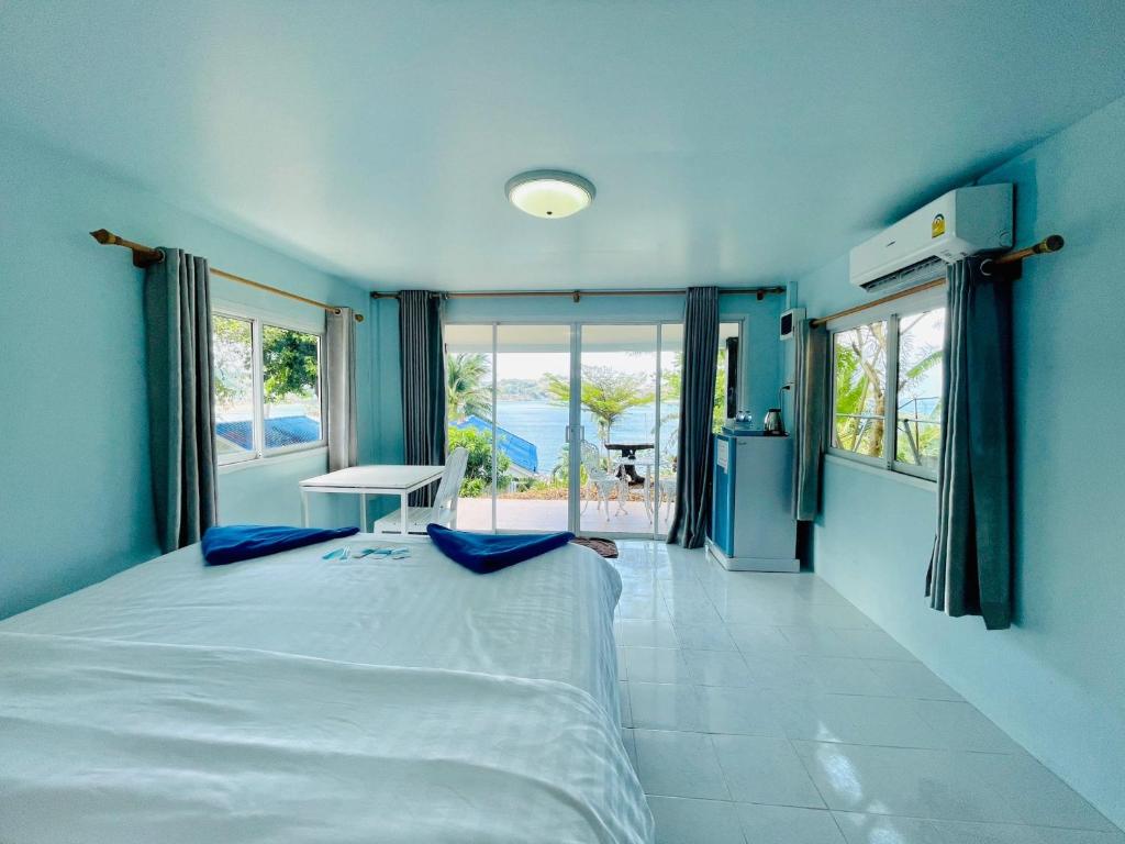 a bedroom with a large bed with blue walls at Naiharn On The Rock Resort Phuket in Nai Harn Beach