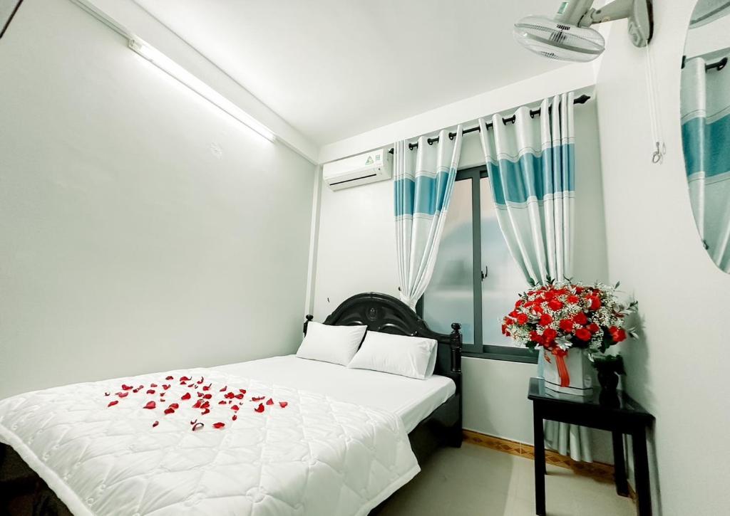 a bedroom with a bed with red roses on it at Be Them homestay in Hue