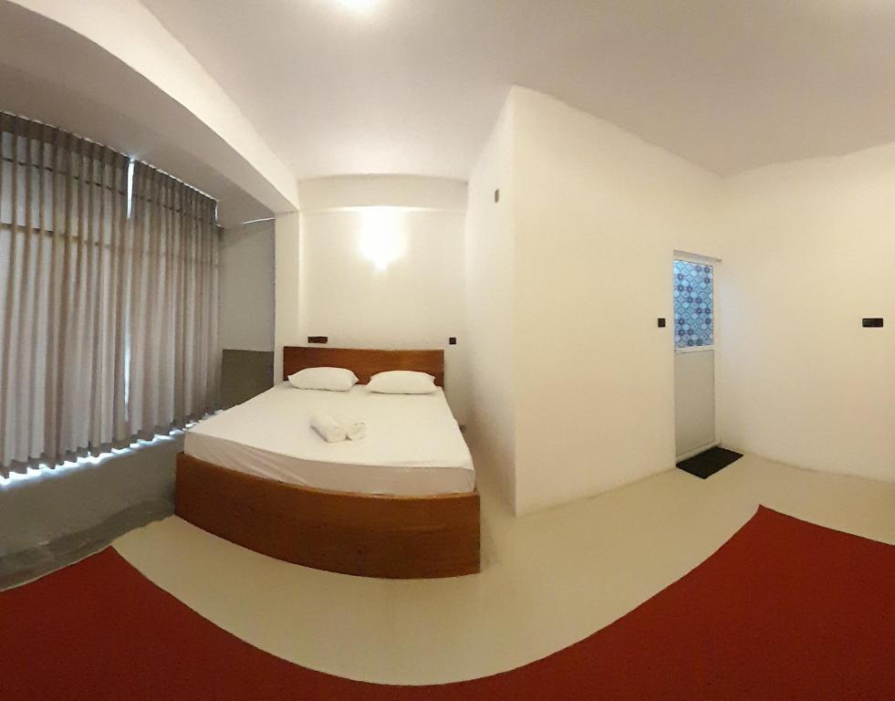 een slaapkamer met een bed in een kamer met een raam bij Sky Heaven Hotel in Kandy