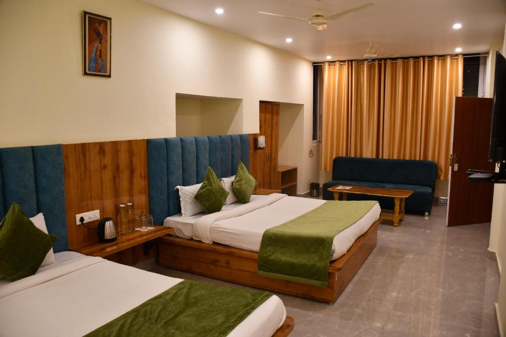 a hotel room with two beds and a couch at Shivansh Inn Resort in Rishīkesh