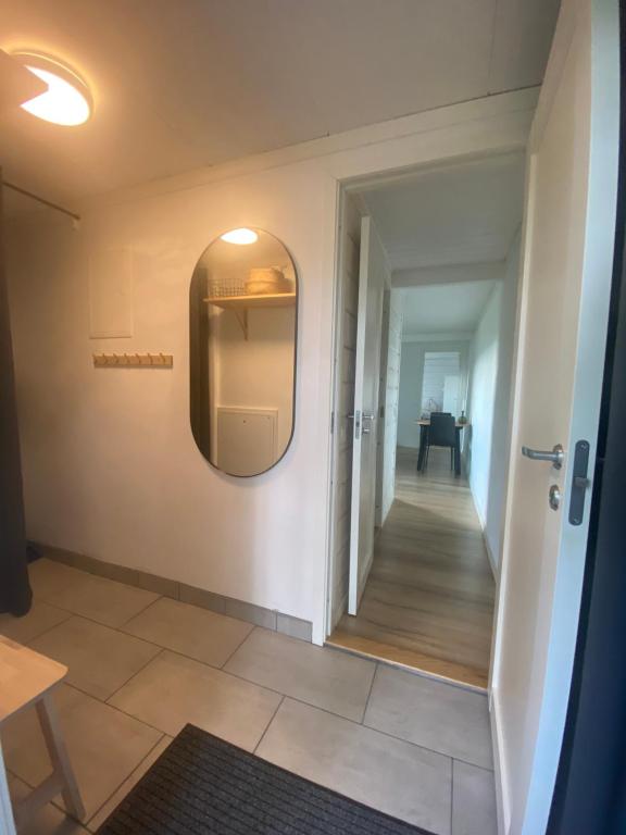 a hallway with a door and a mirror on a wall at Mysig källarlägenhet i Lindvallen in Sälen