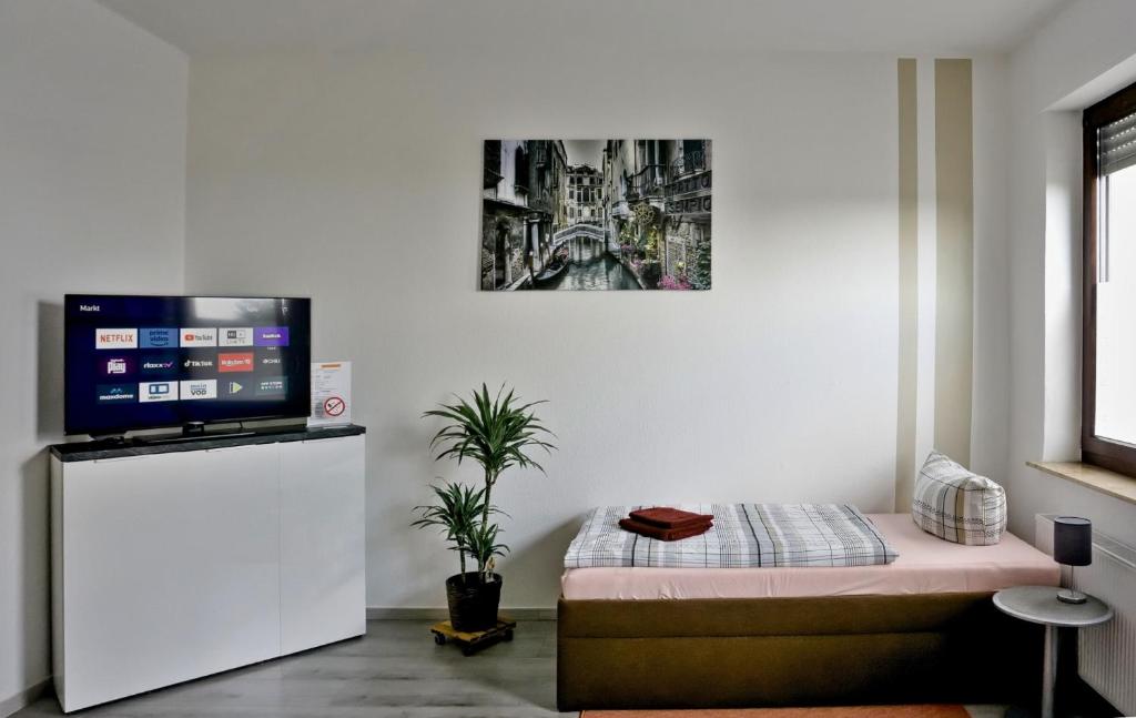 Habitación con TV en una pared blanca en Wohnung für 1 bis 3 Personen, en Solingen