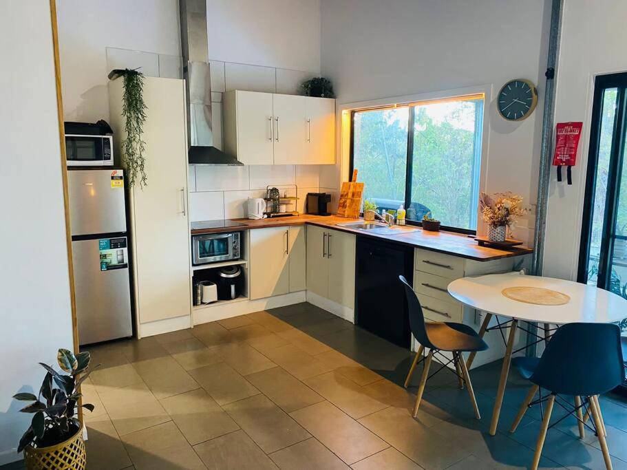 a small kitchen with a table and a table and a table and chairs at Austinville Hinterland Chalet in Neranwood