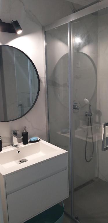 a bathroom with a shower and a sink and a mirror at Aksioma Kotor in Kotor