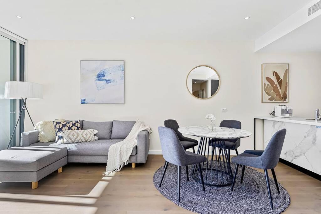 sala de estar con sofá, mesa y sillas en Macquarie Park Executive 2 Bedroom en Sídney