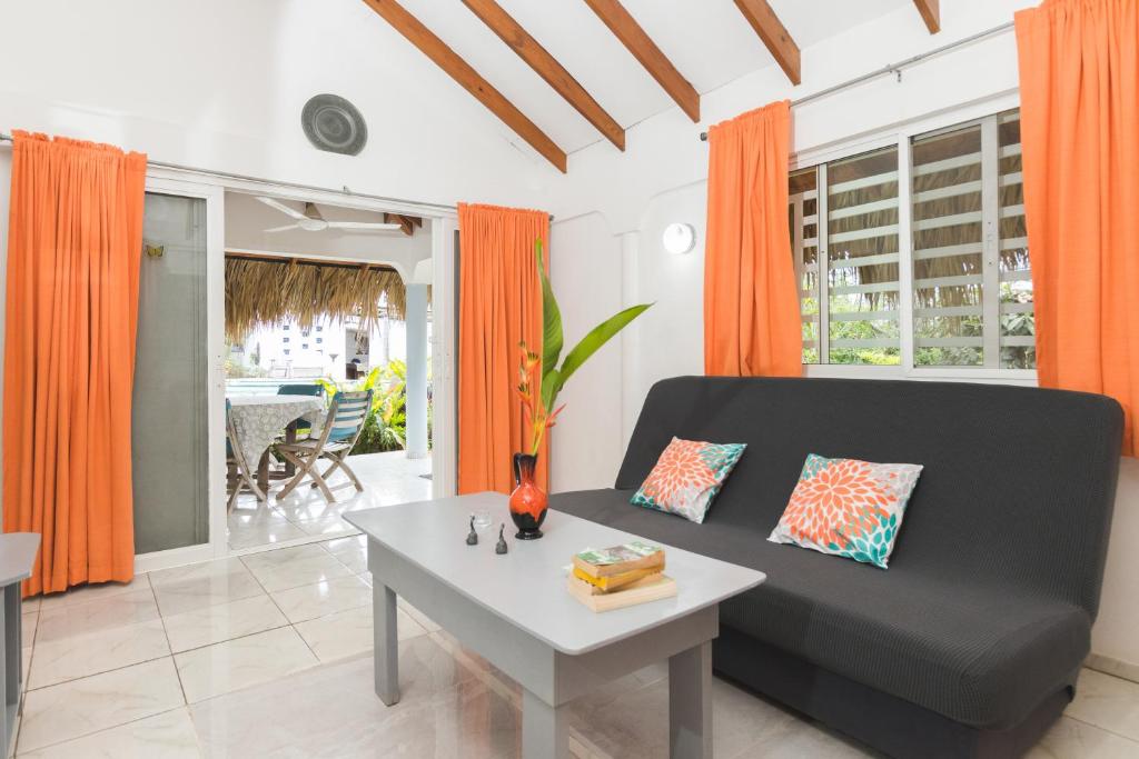 uma sala de estar com um sofá preto e uma mesa em El Flamboyan Apartments em Las Terrenas