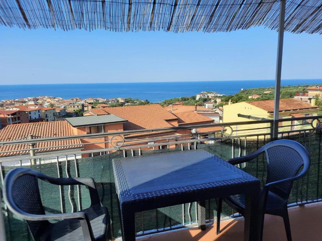 a table and chairs on a balcony with a view of the ocean at Appartamenti Miramare in Marina di Camerota