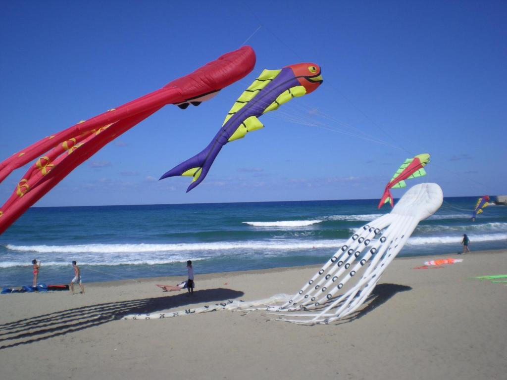 un grupo de cometas volando en la playa en Orizzonte B&B, en Cefalú