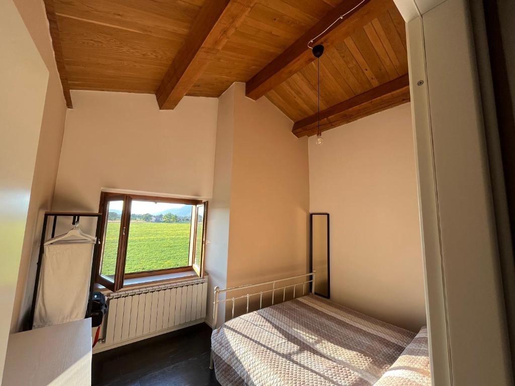 een slaapkamer met een bed en een raam bij trilocale notte nel loft di Lori 3 camere 1 bagno in Gubbio
