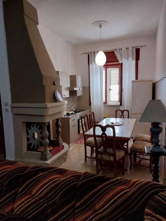 a kitchen and living room with a table and a fireplace at House ALBACHIARA in Otranto
