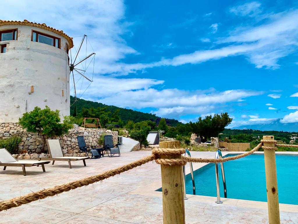 a view of a pool and a windmill at Anemomilos in Koríthion