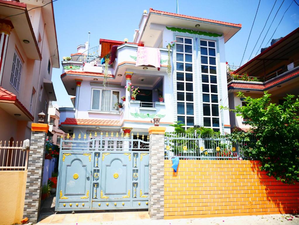 a house with a blue gate and stairs in front at Delights Home in Kathmandu