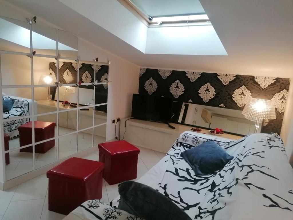um quarto com uma cama e dois bancos em Romantica mansardina in centro città em Pescara