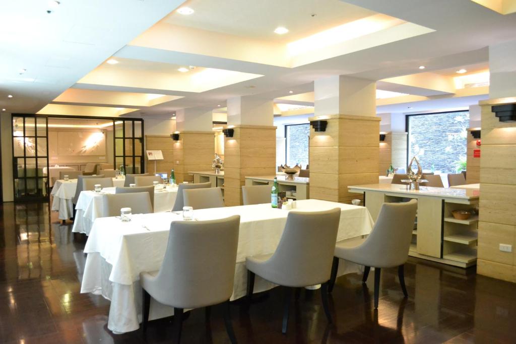 a dining room with white tables and white chairs at The Gaia Hotel - Taipei in Taipei